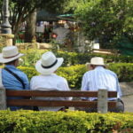 Three friends enjoying the sun on the plaza in Jardin, Colombia